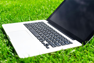 A laptop sitting on green grass