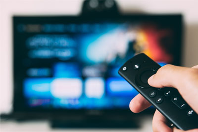 A remote control changing the channel on a smart TV