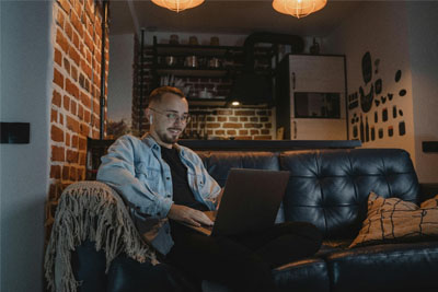 A content young man on a laptop, smiling as he enjoys his secure WiFi