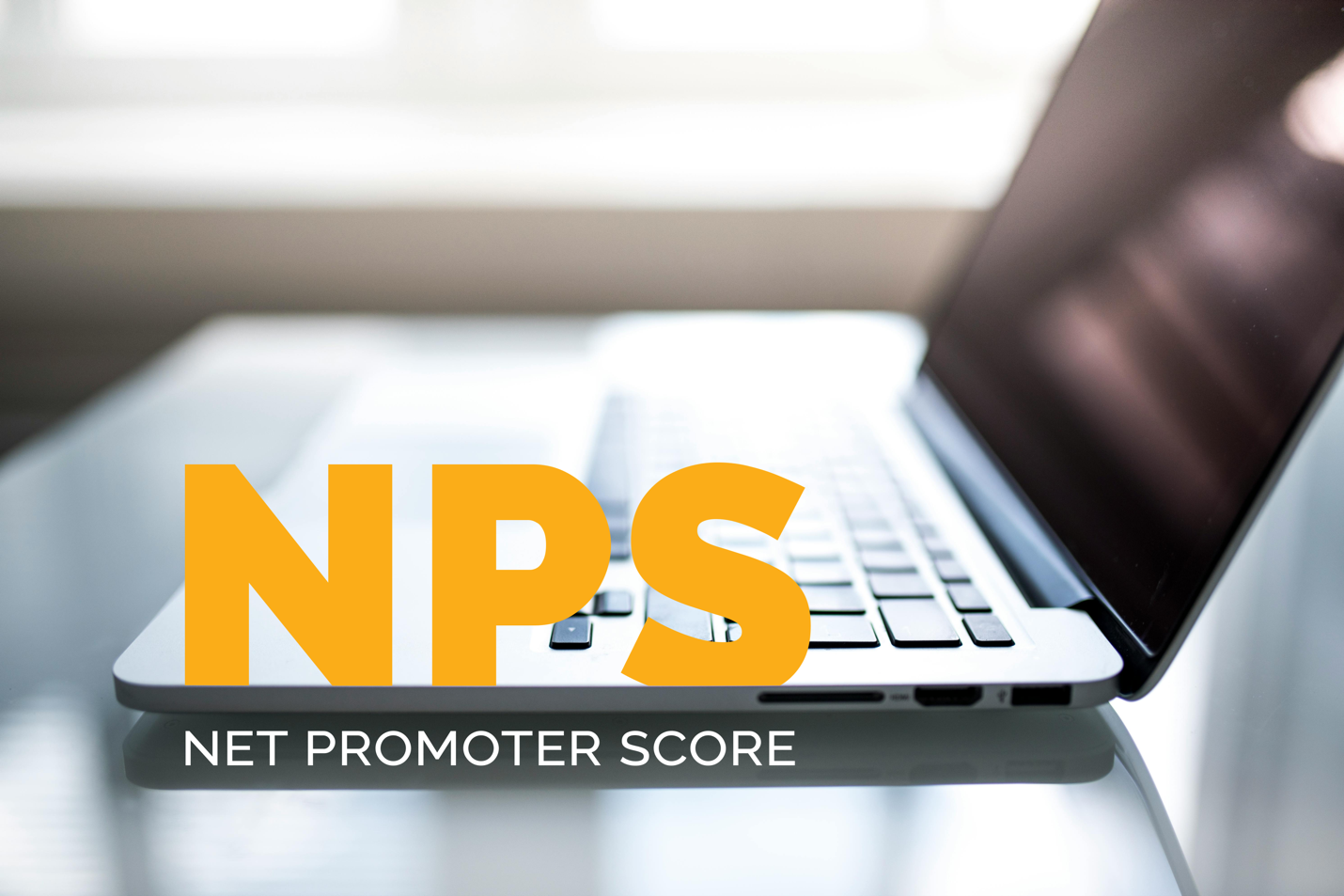 A laptop with the text NPS NET PROMOTER SCORE in front of it