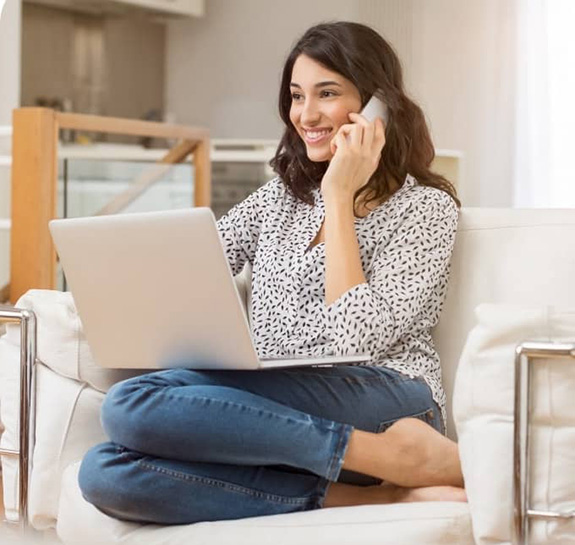 A smiling Glo Fiber Customer Service Representative wearing a headset and sitting at a desk with a computer