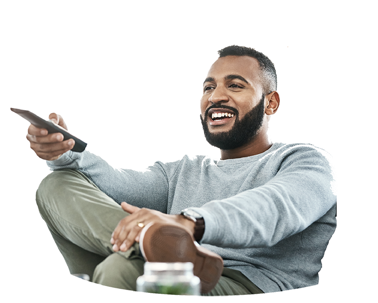 A man streaming local TV with a remote in his hand.